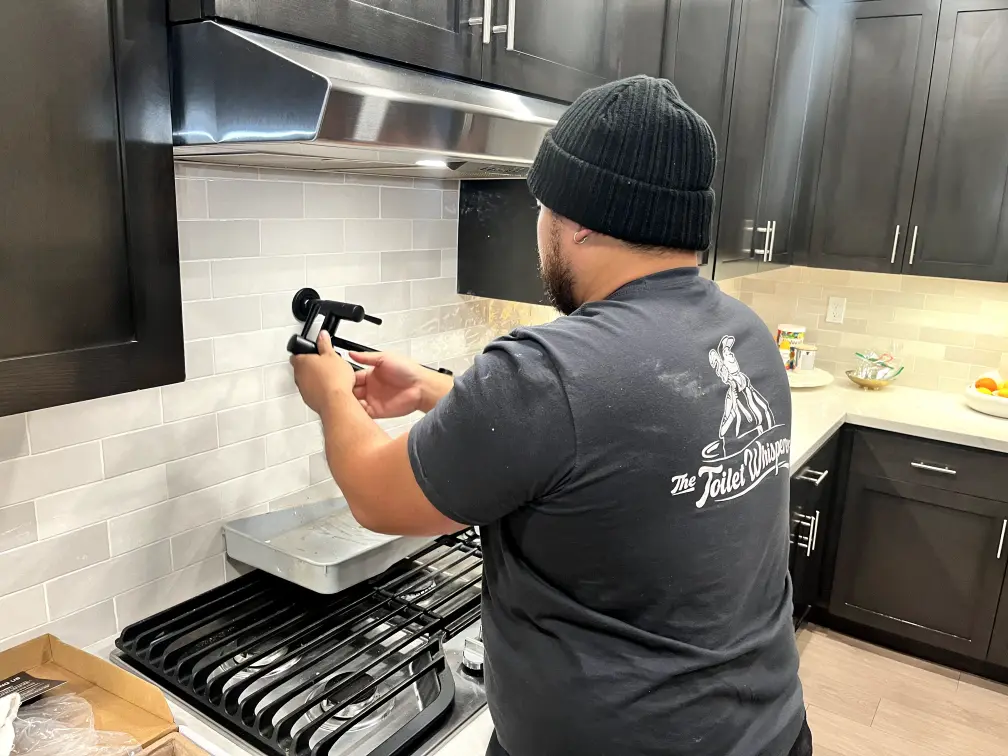 Professional plumber working on residential pipes